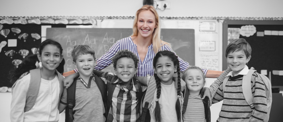 A happy teacher with her students in their classroom