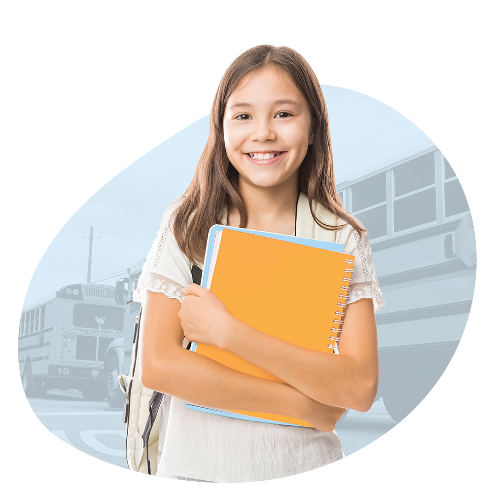 Teenage girl holding yellow notebook in front of school bus