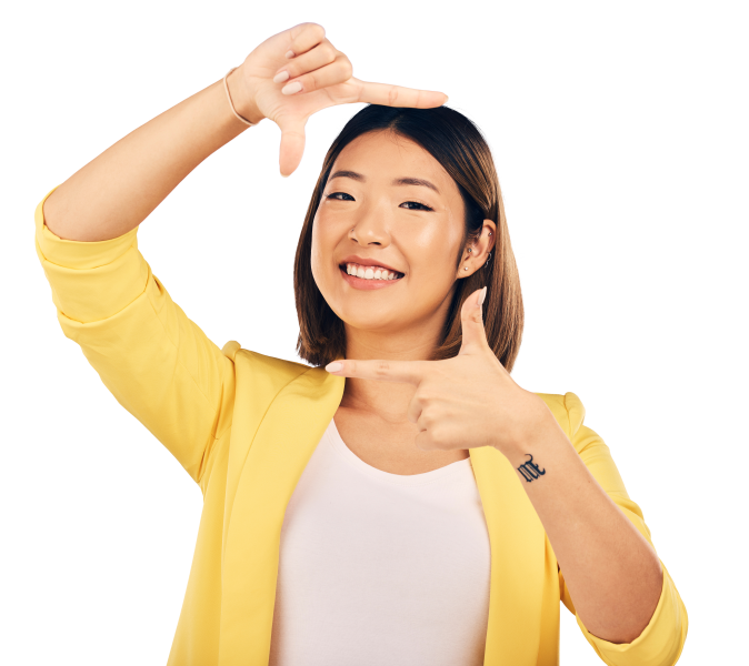 Young woman in yellow jacket making a frame with her fingers around her face